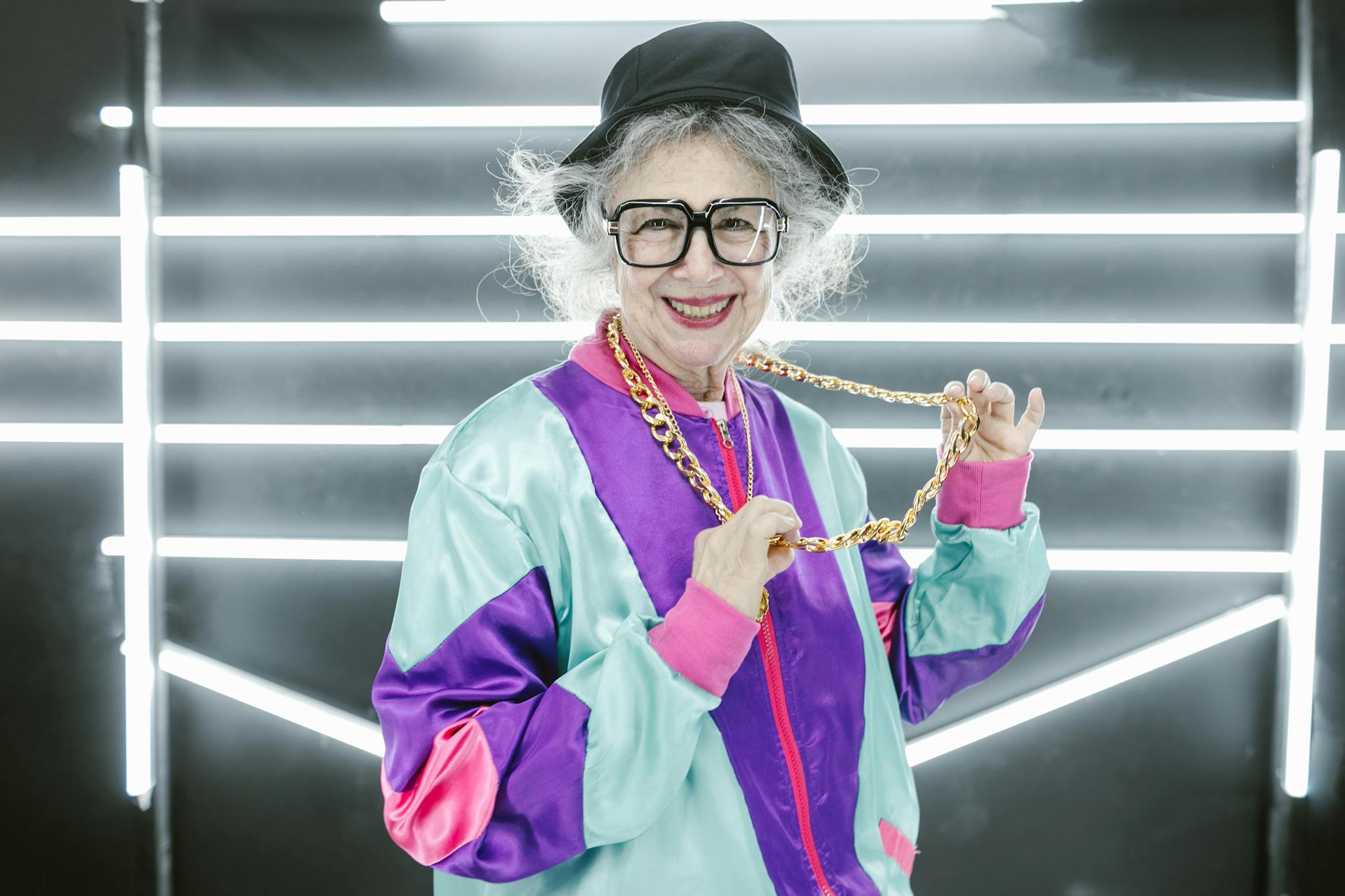 Senior woman in colorful streetwear smiling with confidence indoors.