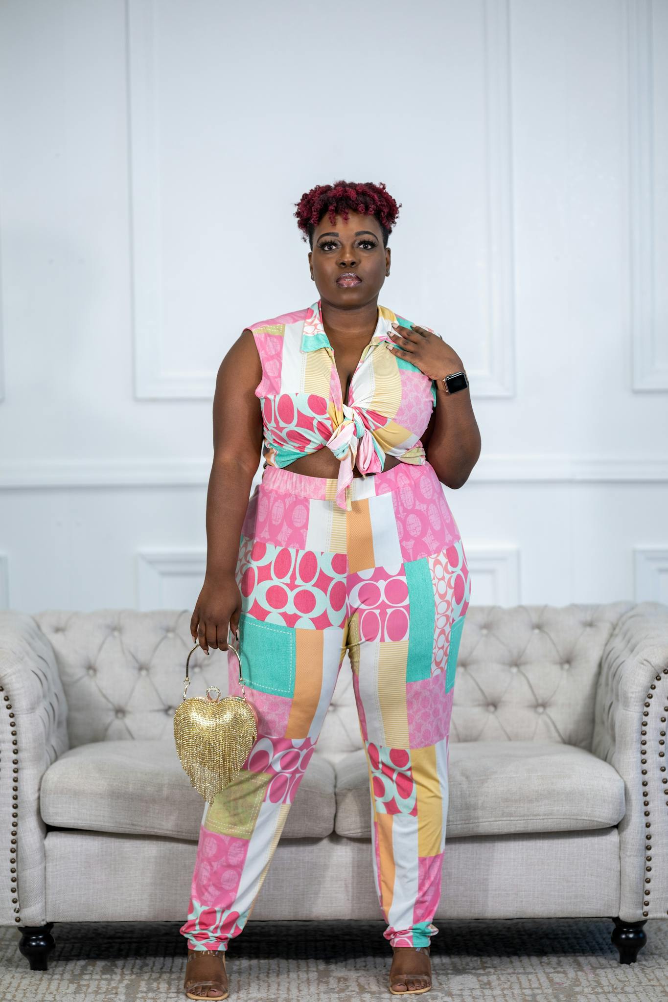 Stylish plus-size model in colorful outfit posing indoors.